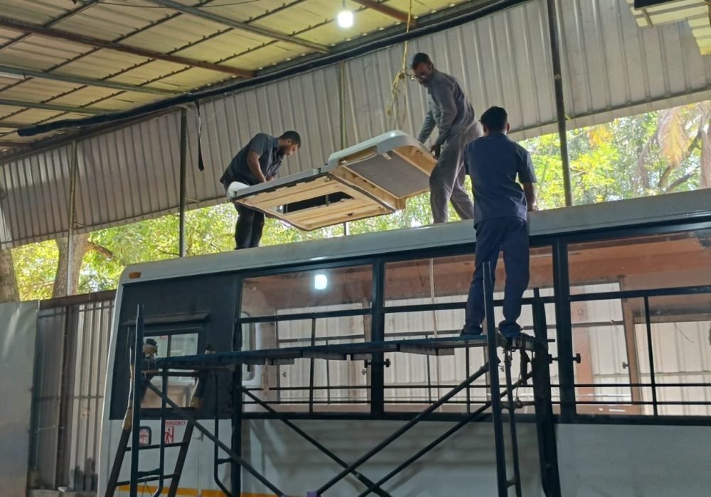 Rooftop air conditioning unit being lifted onto a bus at the Hedo workshop, Edappally, Kochi