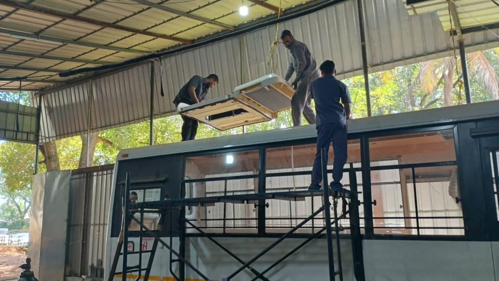 Rooftop air conditioning unit being lifted onto a bus at the Hedo workshop, Edappally, Kochi